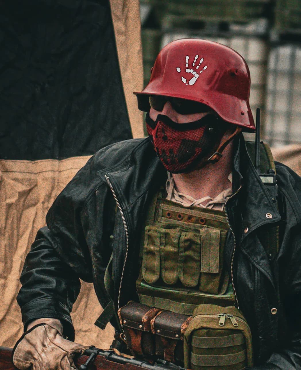 Wastelander in a red helmet, mesh mask, leather jacket, and chest rig
